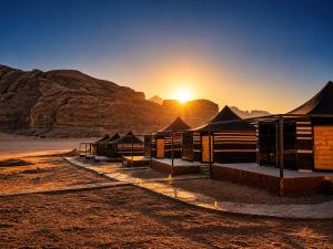 a group of tents in the desert at sunset at Skylight Wadi Rum Camp in Disah