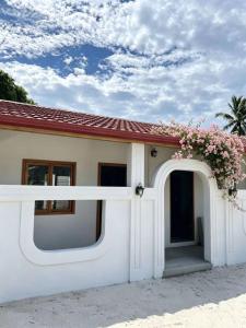 a house with a white door with flowers on it at HB'S iSLAND LiFE in Mathiveri