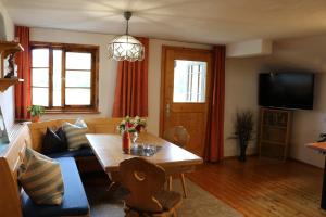 a living room with a table and a couch at Schneiderhof Ferienwohnung mit Alpenblick in Fischbachau