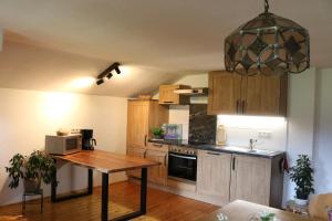 a kitchen with wooden cabinets and a table in it at Schneiderhof Ferienwohnung mit Alpenblick in Fischbachau