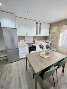 a kitchen with a wooden table and a refrigerator at Casa Zoila in Porto do Son