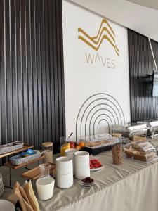 a table with food and a wave sign on a wall at Waves Hotel NEW IN 2026 in Sarajevo