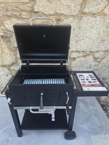 a barbecue grill sitting on a table next to a wall at Casa Zoila in Porto do Son