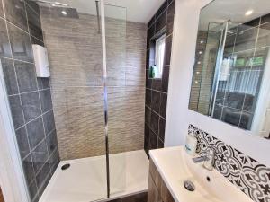 a bathroom with a shower and a sink at 67 Broadside Holiday Chalet near Broads & Beaches in Stalham