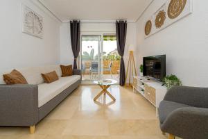 a living room with a couch and a tv at Appartement Capitolio Albir 1G in Albir