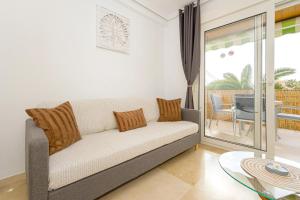 a living room with a couch and a balcony at Appartement Capitolio Albir 1G in Albir