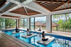 a group of people doing yoga in a pool at The Ritz-Carlton Okinawa in Nago