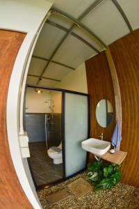 a bathroom with a mirror and a sink and a toilet at ไร่ชาอาโซ -ที่พักดอยช้าง in Ban Huai Khai +50 photos