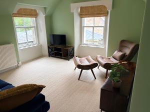 a living room with two chairs and a television at Myrtlebank in Pitlochry