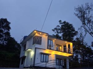 a white house with lights on the side of it at Venus Valley Vagamon in Vagamon
