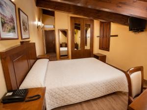 a bedroom with a bed and a desk with a keyboard at Hotel Rural El Verdenal in Noceda del Bierzo