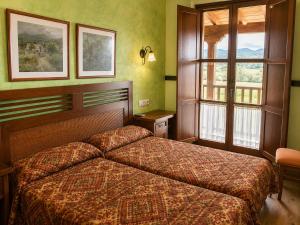 a hotel room with a bed and a window at Hotel Rural El Verdenal in Noceda del Bierzo