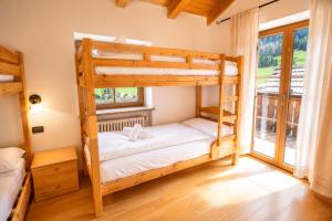 a bedroom with two bunk beds and a window at Appartamenti Pollam by AMA Val di Fassa in Pozza di Fassa