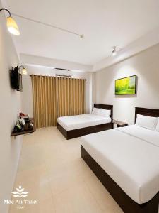 a hotel room with two beds and a television at Mộc An Thảo Hotel in Quy Nhon