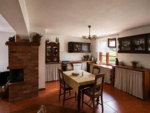 a kitchen with a table with chairs and a fireplace at Siedlisko Mieruniszki in Mieruniszki