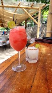 a drink in a glass sitting on a wooden table at Casa Bambú Hotel in Masaya