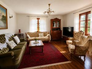 a living room with couches and a tv at Siedlisko Mieruniszki in Mieruniszki
