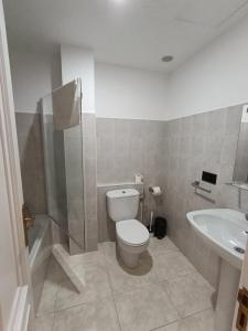 a bathroom with a toilet and a sink at Pensión Pastoriza in Vimianzo