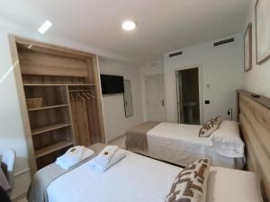 a hotel room with two beds and a tv at Pensión Pastoriza in Vimianzo