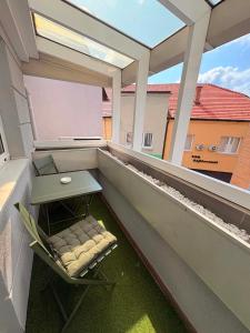 ein Balkon mit einem Tisch und einem Stuhl auf einem Balkon in der Unterkunft Soni Trg in Tuzla