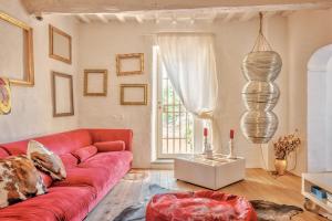 a living room with a red couch and a large window at Antica Dimora in Capolona