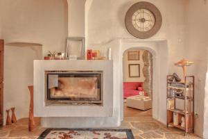 a living room with a fireplace with a clock on the wall at Antica Dimora in Capolona