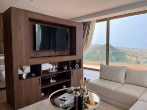 a living room with a couch and a tv at Dar Zaha in Aguenouane