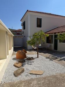 a garden with a small tree and a house at Apollon Heritage House in Palaiókipos