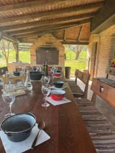 a long wooden table with plates and wine glasses at Weekendica Aljmaš in Aljmaš