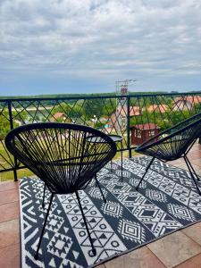 two chairs sitting on top of a balcony with a view at Weekendica Aljmaš in Aljmaš