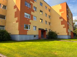 ein Mehrfamilienhaus mit einem grünen Rasen davor in der Unterkunft Stylish & Bright ARTpartment- Family -Friendly in Haapsalu