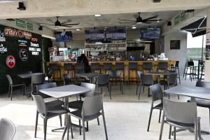 a restaurant with tables and chairs and a bar at Hacienda del Sur in Santa Isabel