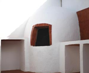 a white building with a window in it at CALMA TIPI Glamping con piscina en Chiclana in Chiclana de la Frontera +31 photos