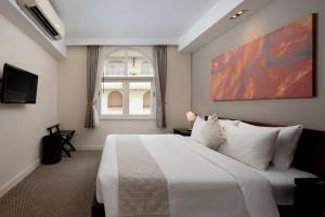 a bedroom with a large white bed and a window at Central Mansions Hotel and Apartments in Phnom Penh +75 photos