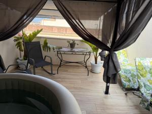 a patio with a table and chairs and curtains at Suite SWEET DREAMS Dan champs in San Vito lo Capo