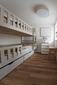 a bedroom with white bunk beds and a table at Elbsandsteinlodge in Sebnitz