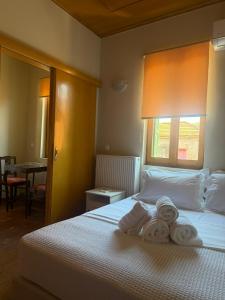 a hotel room with a bed with towels on it at Apollon Heritage House in Palaiókipos