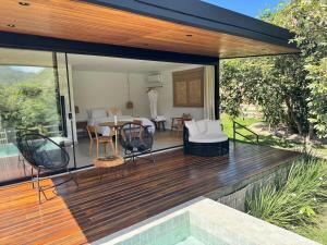 a wooden deck with a table and chairs on it at Arandu Bangalô in Cavalcante