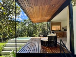 a wooden deck with a swing and a house at Arandu Bangalô in Cavalcante
