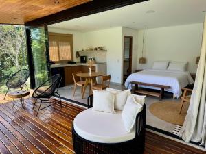 a bedroom with a bed and a kitchen with a table at Arandu Bangalô in Cavalcante