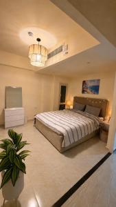 a bedroom with a large bed and a chandelier at 1 BDR Pool Front Cozy Apartment in Port Ghalib