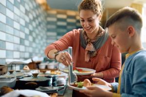 a woman serving a boy a plate of food at Hyatt Select Louisville North in Jeffersonville