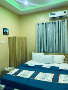 ein Schlafzimmer mit einem großen Bett mit blau-weißer Bettwäsche in der Unterkunft Larrydam hotel in Ilesa