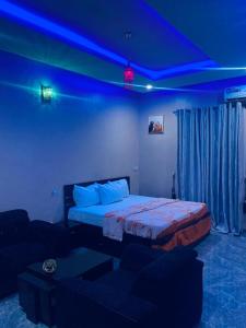 ein Schlafzimmer mit einem Bett und einer blauen Decke in der Unterkunft Larrydam hotel in Ilesa