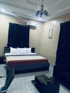 ein Schlafzimmer mit einem großen Bett und blauen Vorhängen in der Unterkunft Larrydam hotel in Ilesa