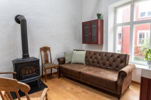 a living room with a leather couch and a stove at Villa Vimmerby in Vimmerby