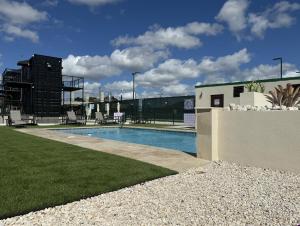 a swimming pool with chairs and a building at Hacienda del Sur in Santa Isabel