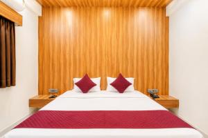 a bedroom with a white bed with red pillows at Hotel The Lavendra Heritage in Patna