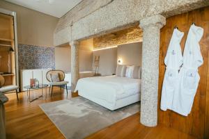 a bedroom with a white bed and a column at Torel Royal Court in Guimarães +78 photos