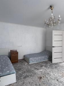 a bedroom with a bed and a chandelier at Maximus in Bokonbayevo